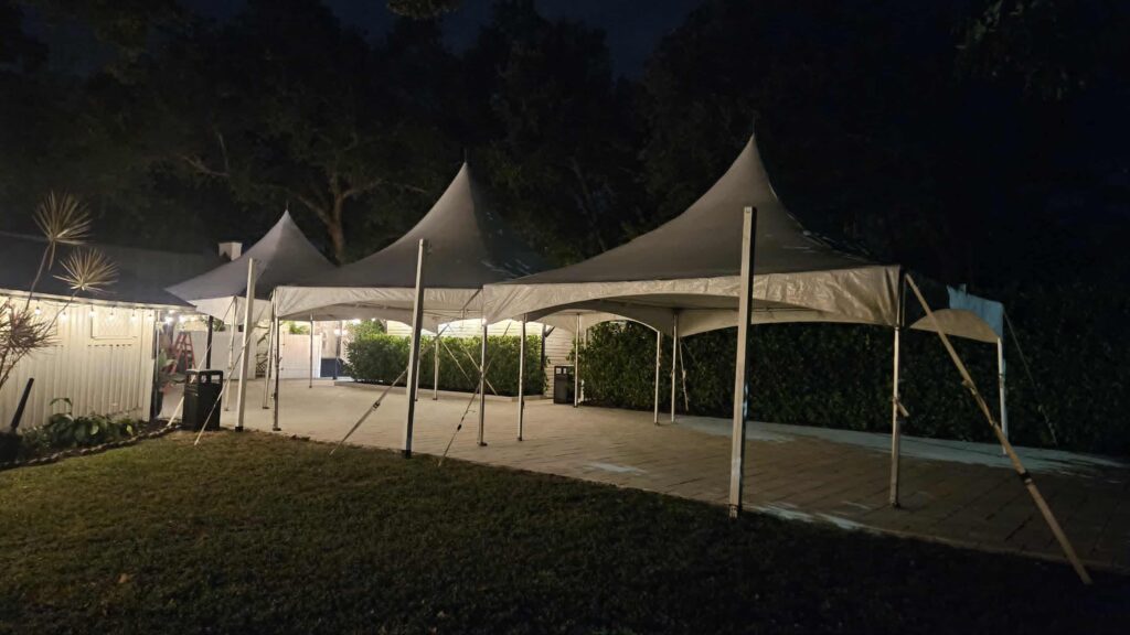A backyard event tent with tables and chairs arranged for a birthday party in Fort Myers, Florida.