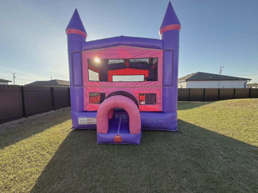 Bounce house rentals in Gateway — purple and pink castle bounce house set up in a backyard