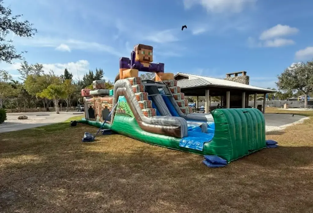 Bounce house rentals in Gateway — large themed water slide inflatable set up at a park for a party