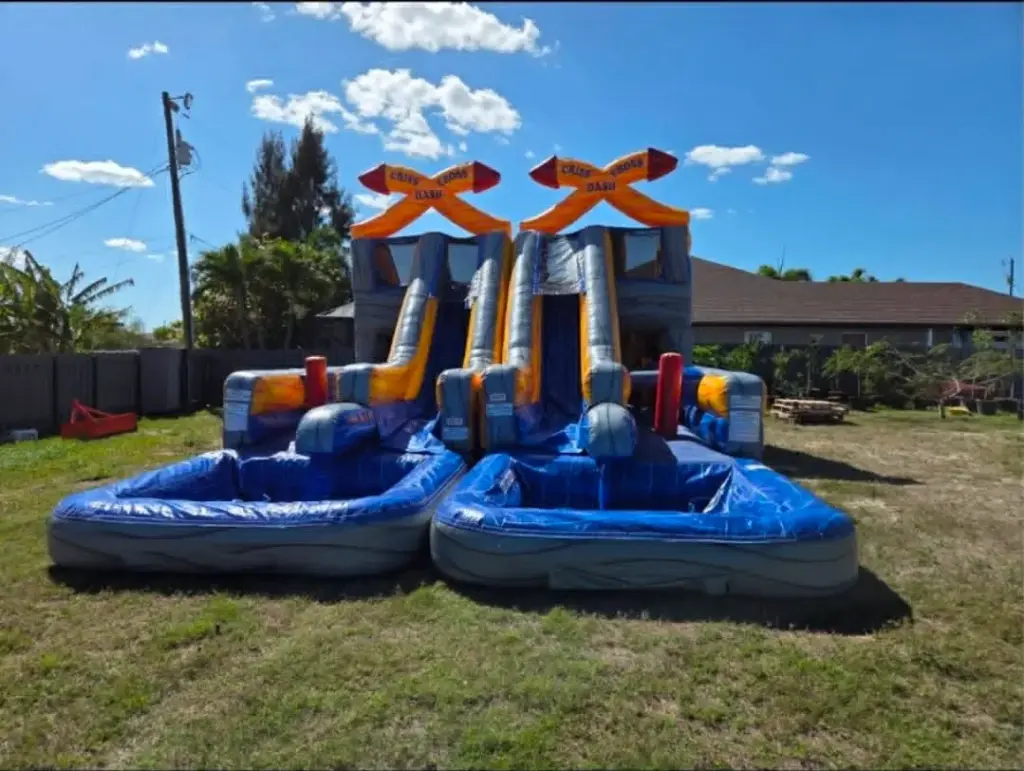 Party rentals in Cape Coral FL — dual lane inflatable water slide with splash pools set up in a backyard